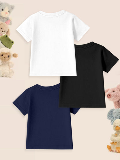 Three plain kids t-shirts in white, black, and navy with plush animal toys on pastel background