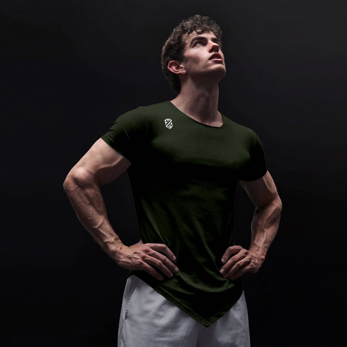 Athletic man in black fitted t-shirt with logo, posing confidently against dark background