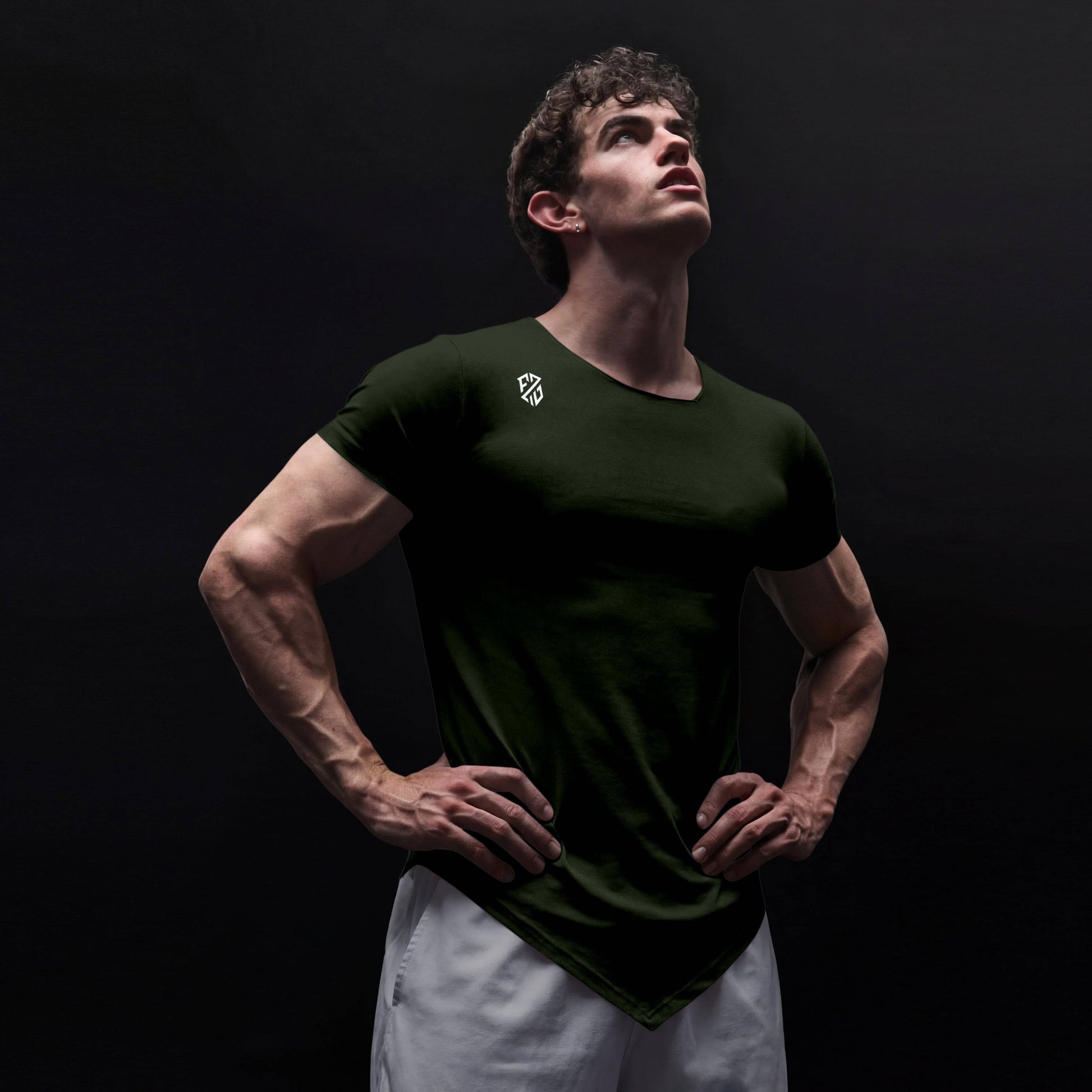 Athletic man in black fitted t-shirt with logo, posing confidently against dark background