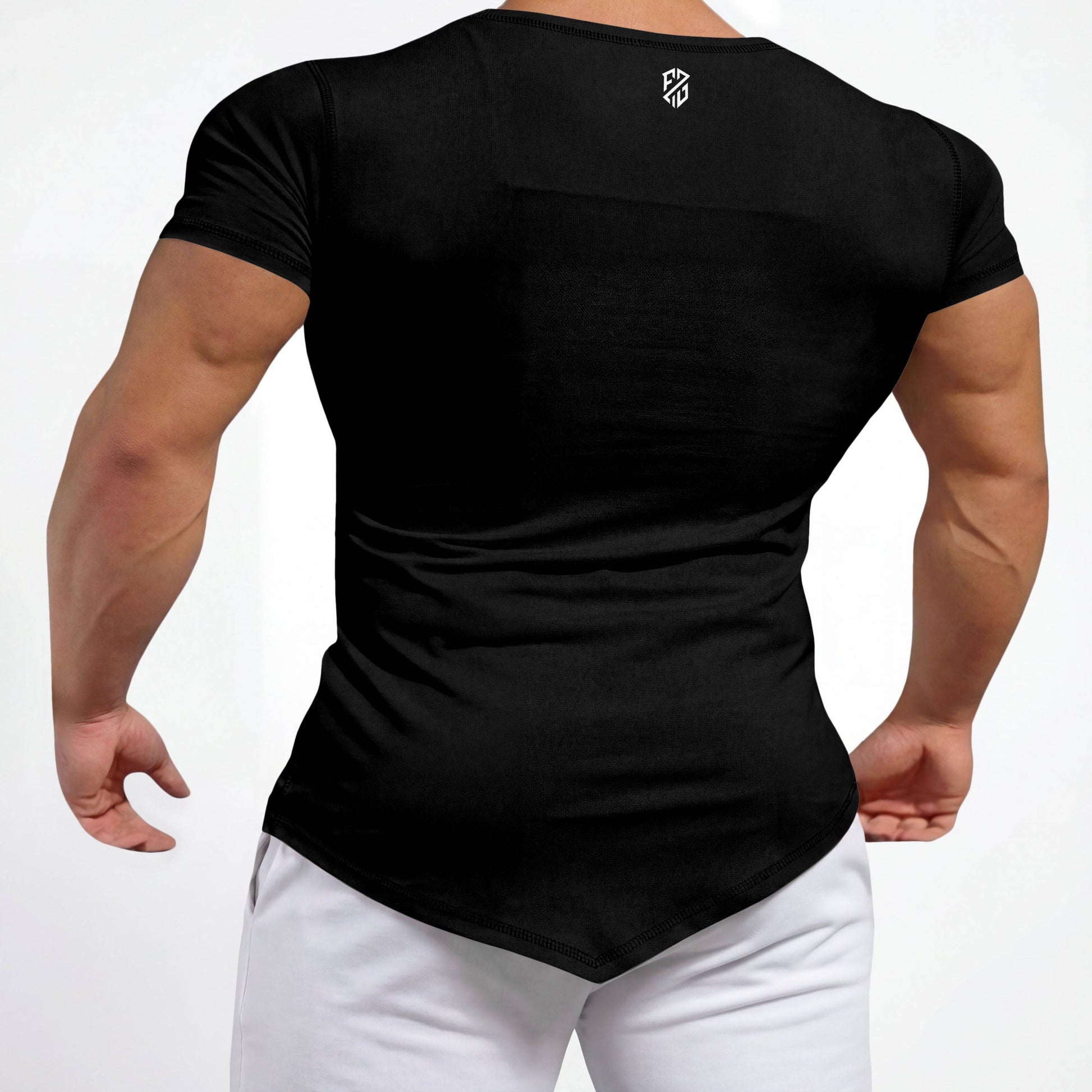 Man wearing fitted black athletic t-shirt with logo, white pants, back view