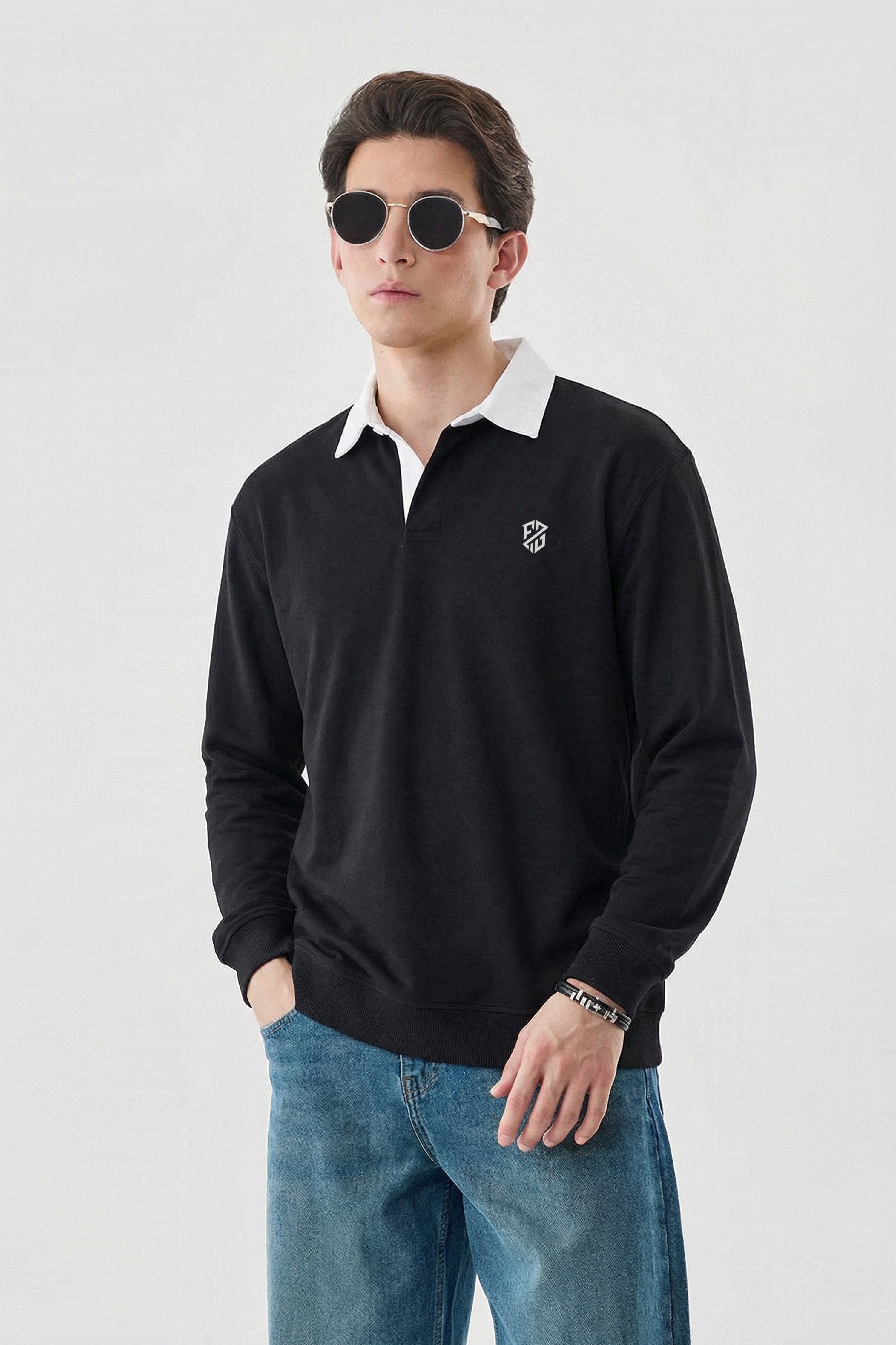 Man wearing black long sleeve rugby shirt with white collar, round sunglasses, and blue jeans