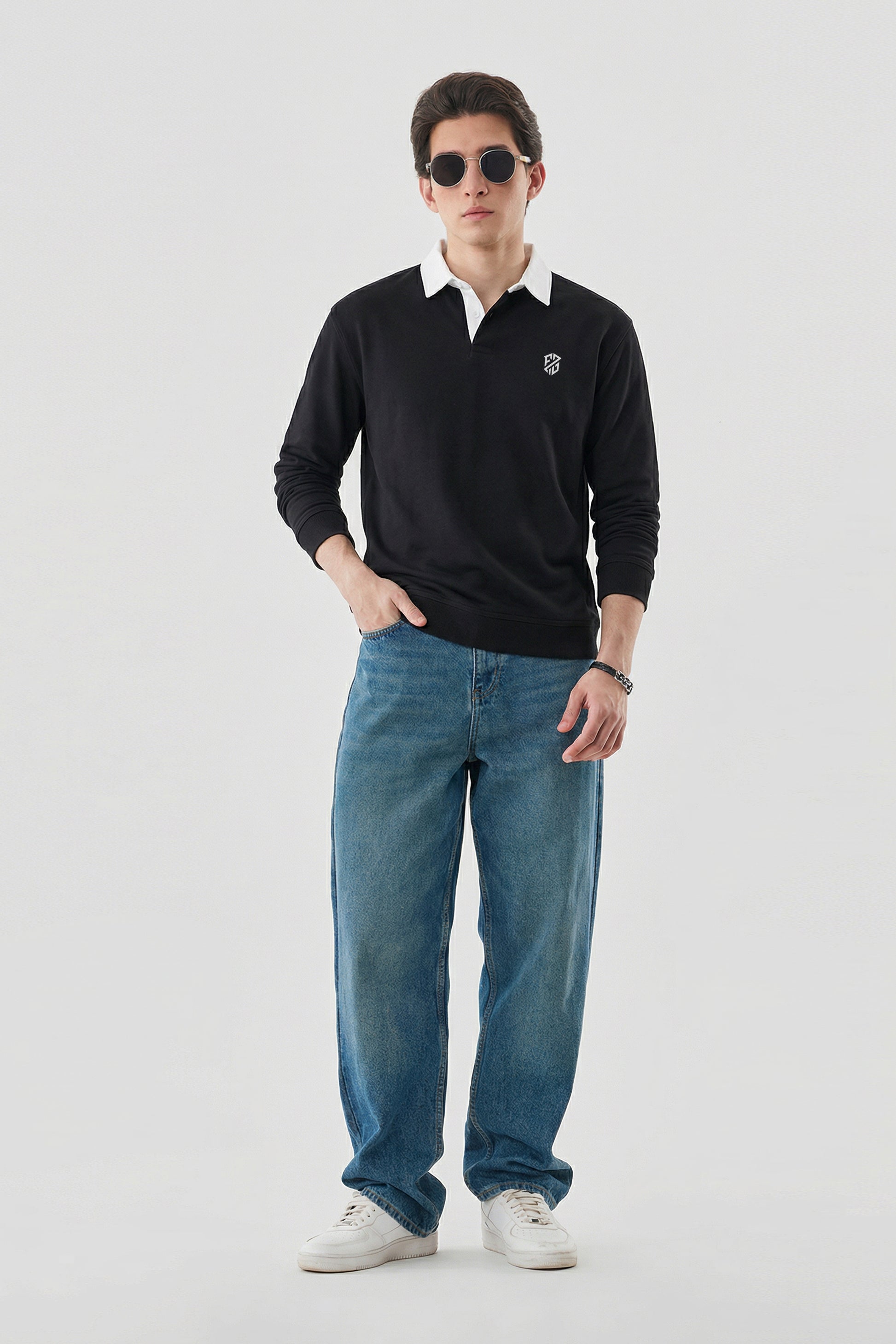 Man wearing black long sleeve polo with white collar, blue jeans, and white sneakers