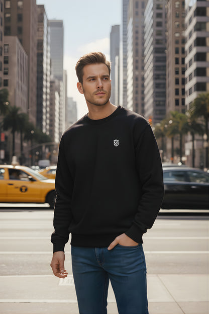 Man in black crewneck sweatshirt and jeans standing on city street with yellow taxi in background