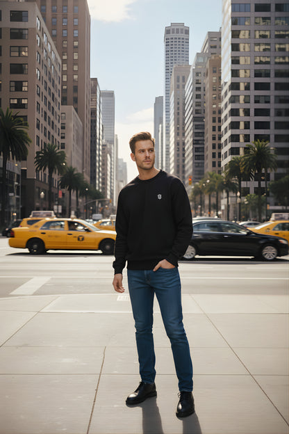 Man in black sweatshirt and blue jeans standing on city street with taxis and skyscrapers