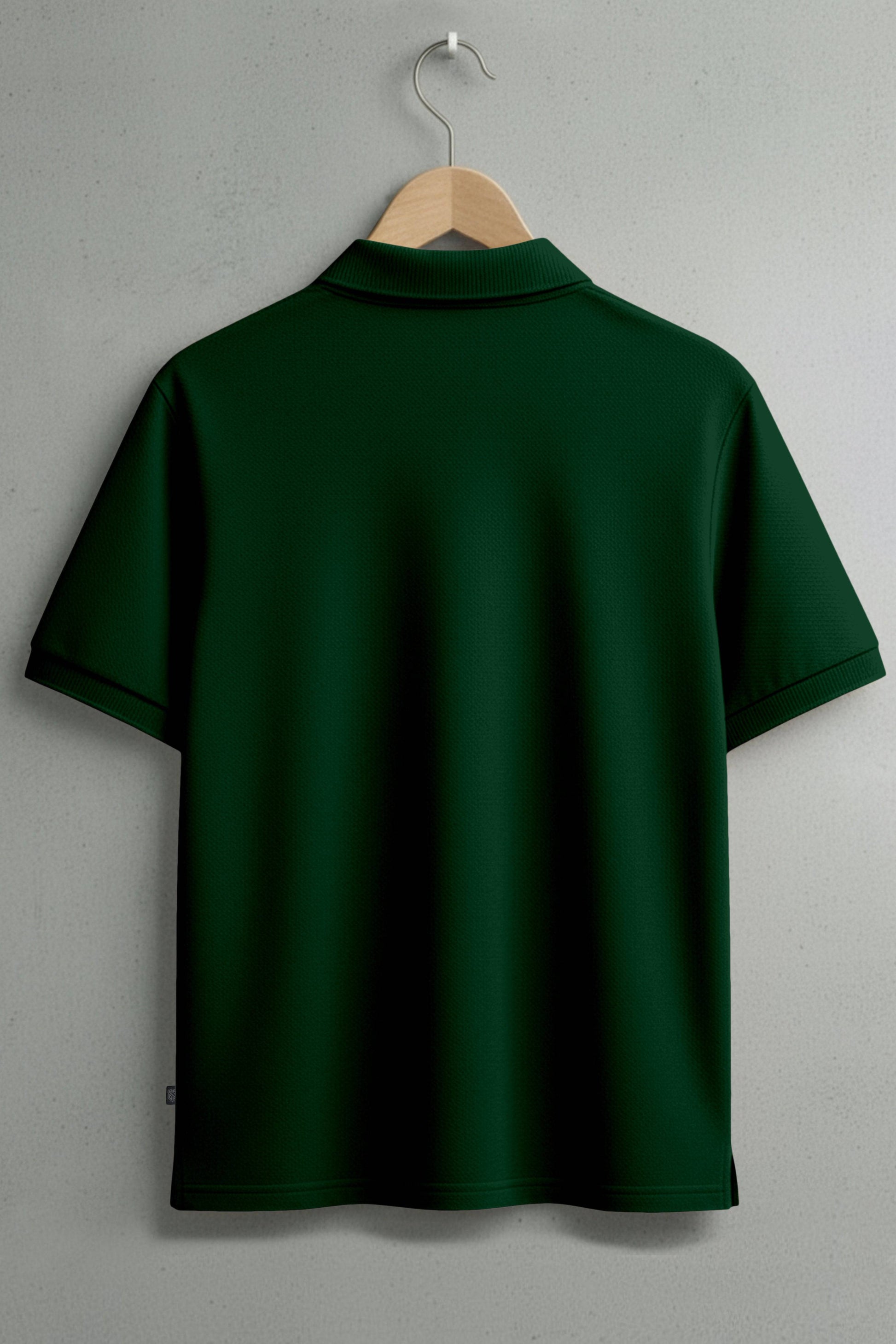 back view of dark green short sleeve polo shirt on a hanger against a plain wall