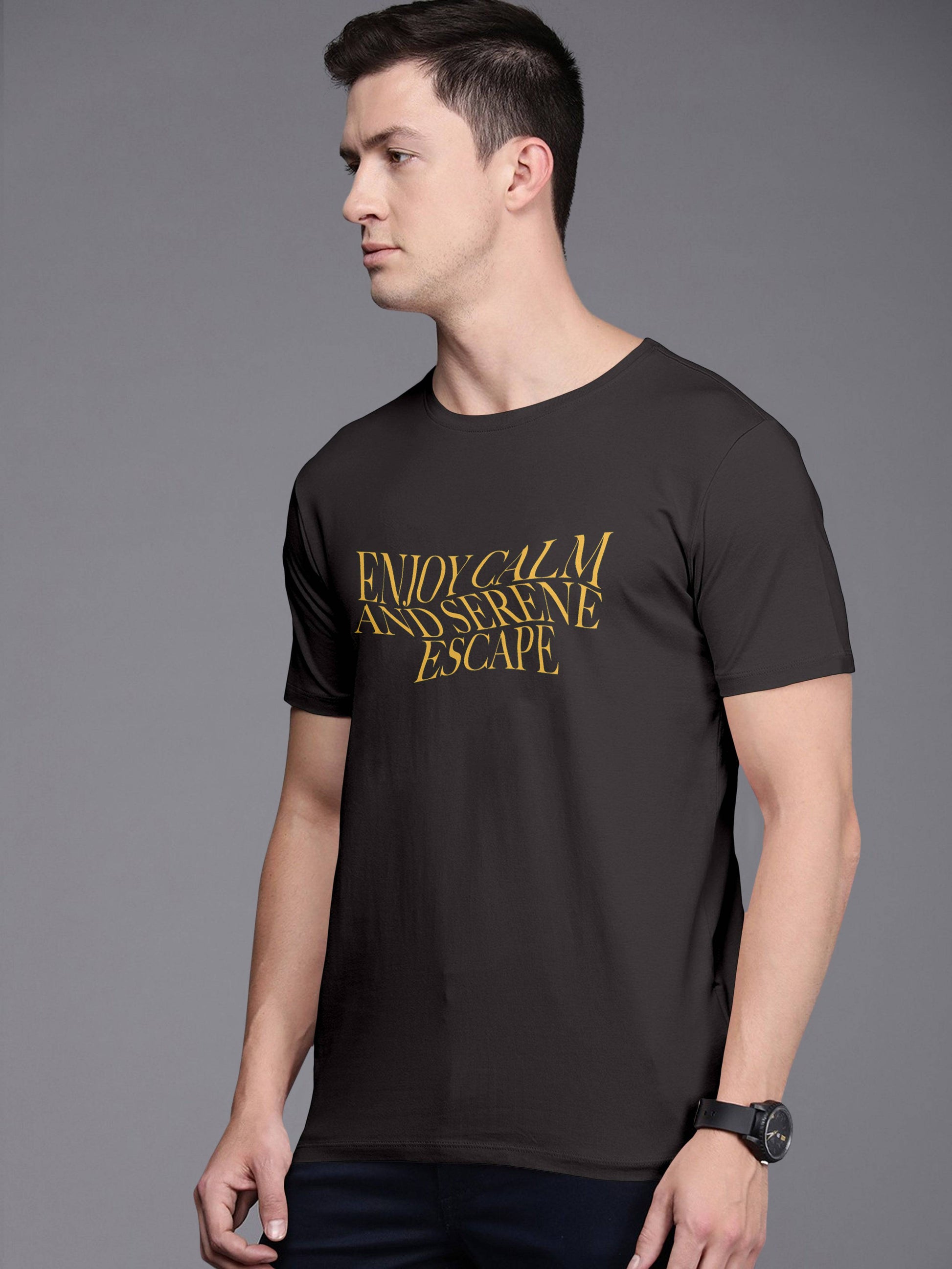 Man wearing black t-shirt with yellow text 'Enjoy Calm and Serene Escape' on front