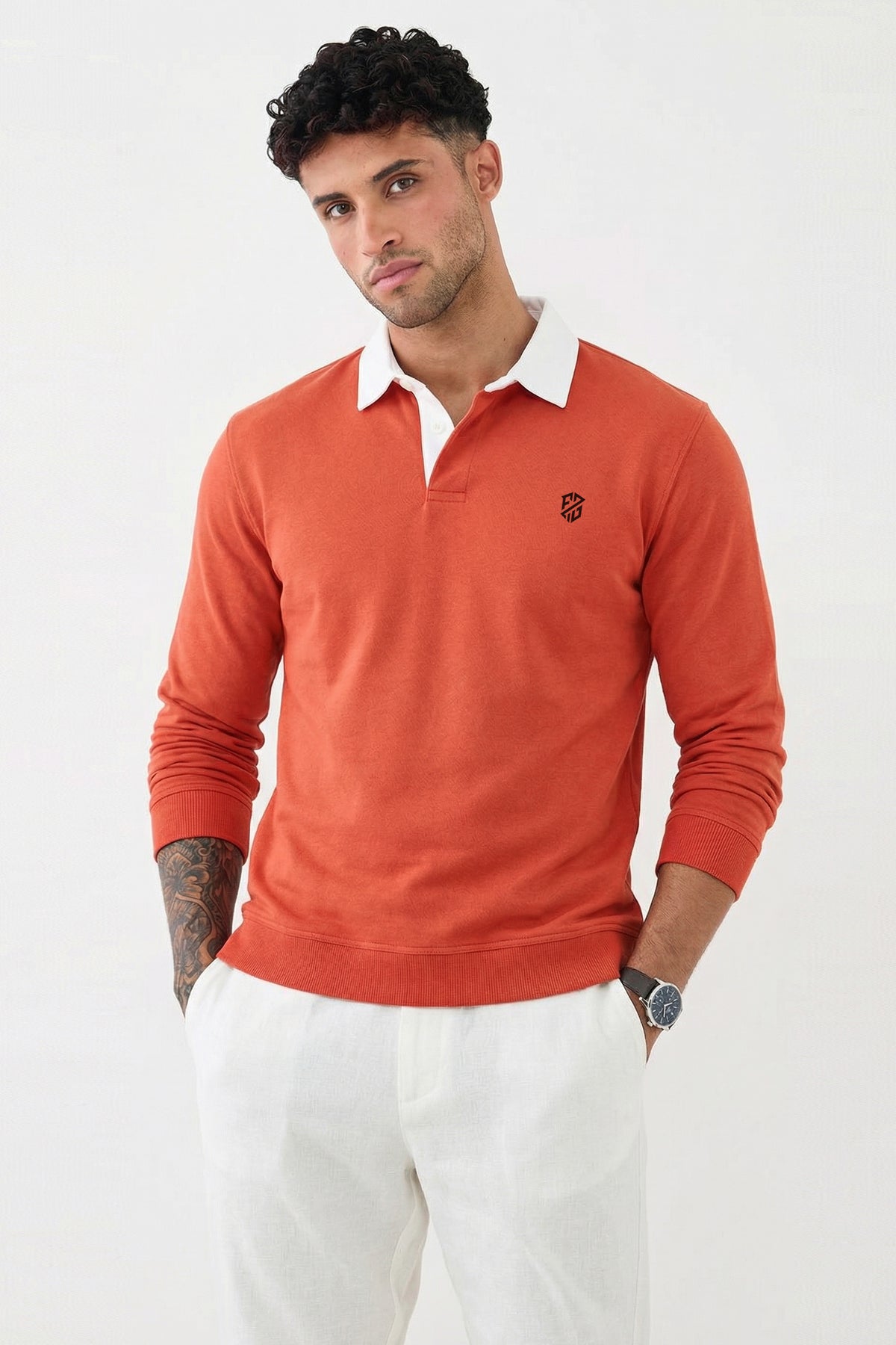 Man wearing an orange long-sleeve polo shirt with white collar and white pants