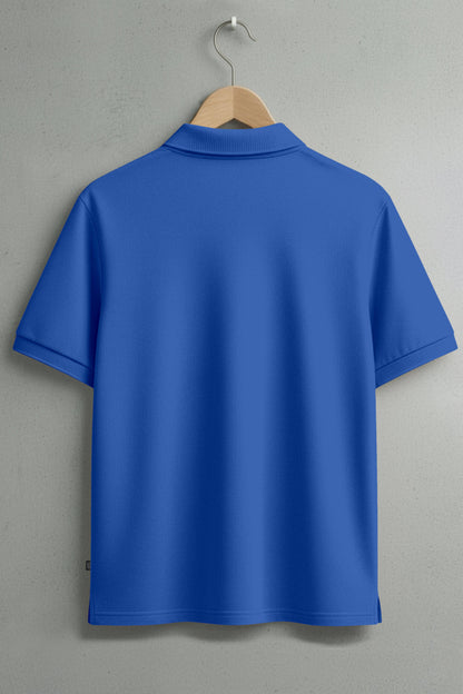 Back view of plain blue polo shirt on hanger against gray wall