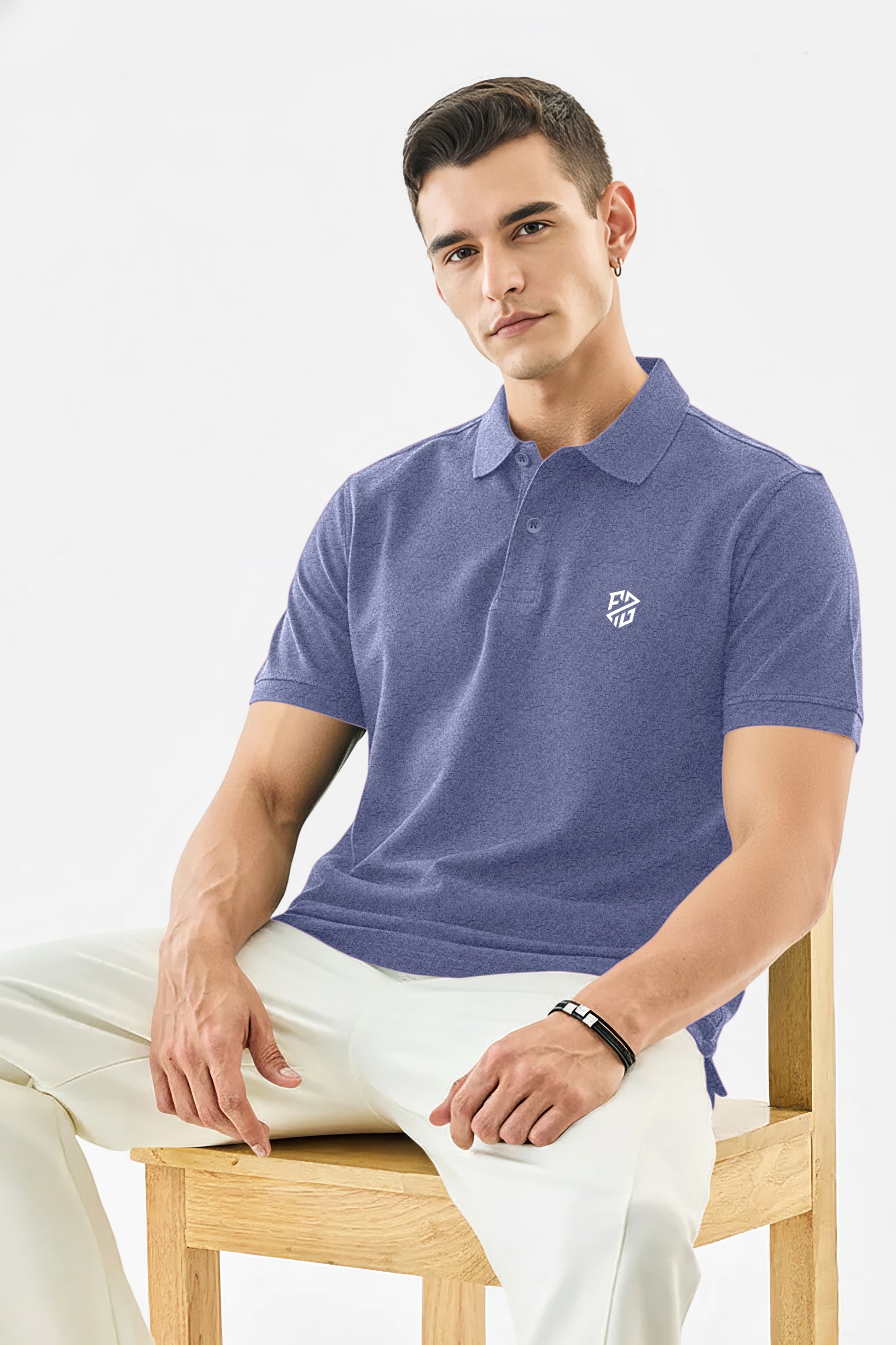 Man wearing a blue short sleeve polo shirt with chest logo, sitting on wooden chair