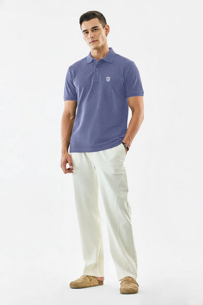 Man wearing a lavender polo shirt with logo, white trousers, and brown loafers, on white background