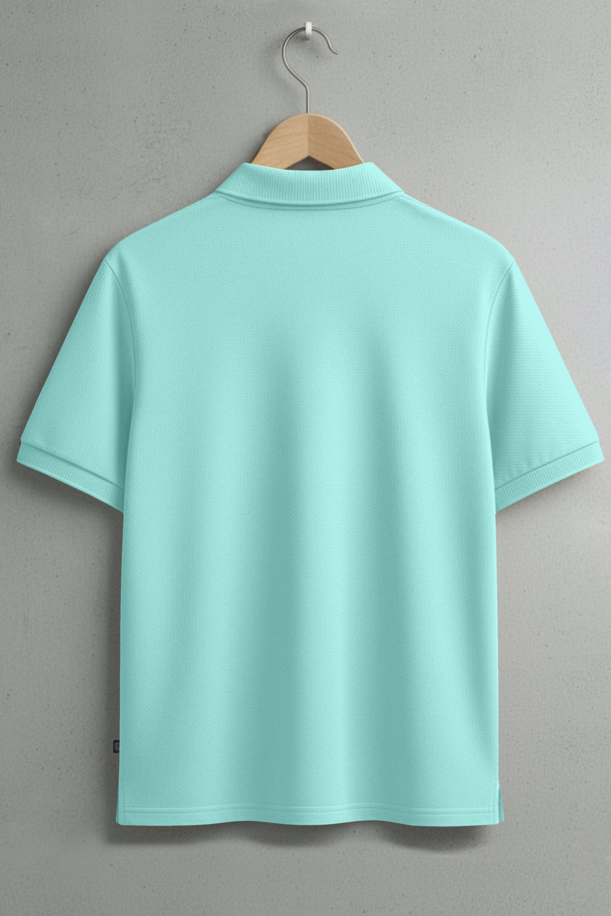 Light blue short sleeve polo shirt on hanger against gray wall, back view