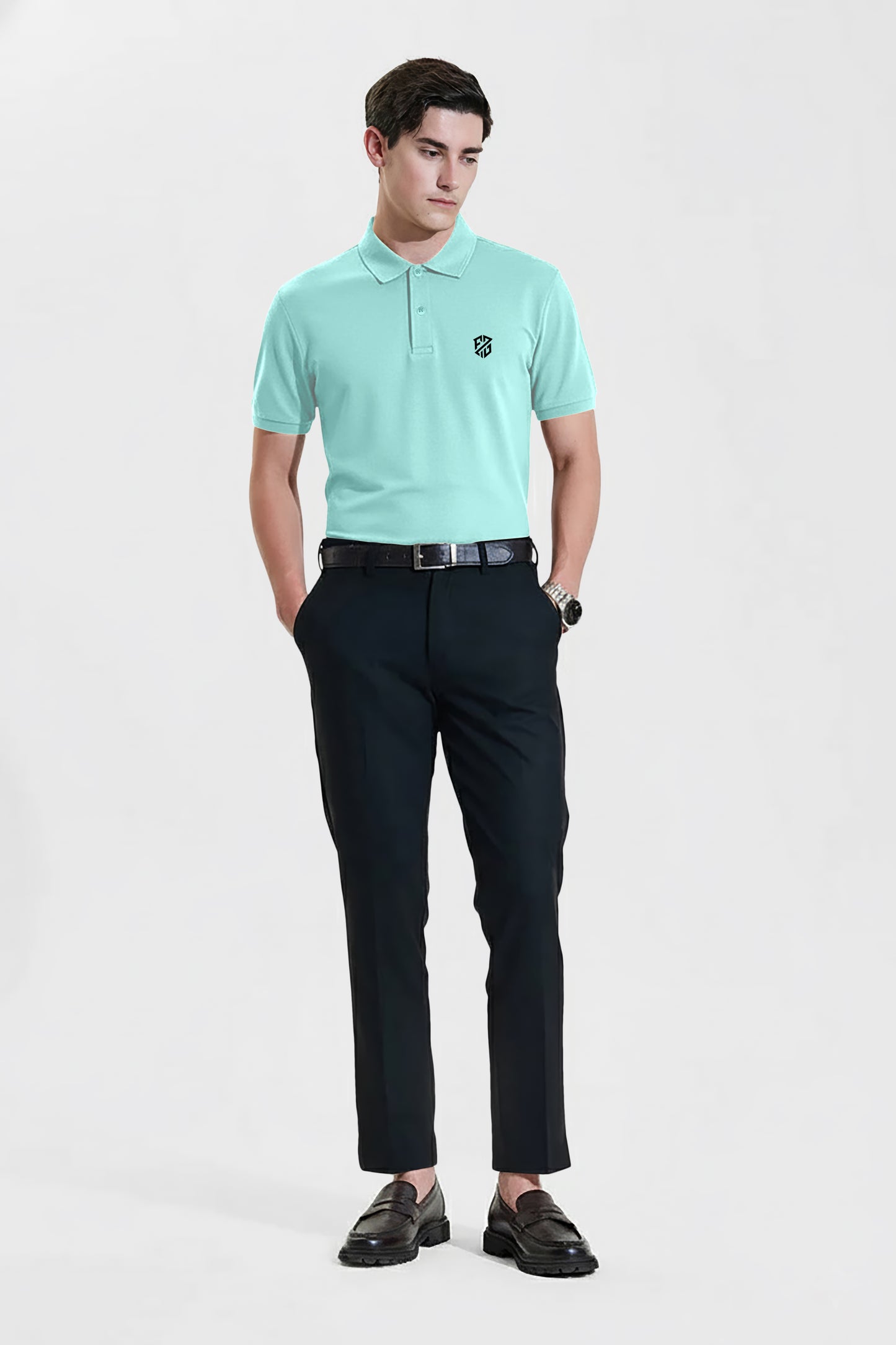 Man wearing mint green polo shirt with logo and black dress pants, standing on white background.