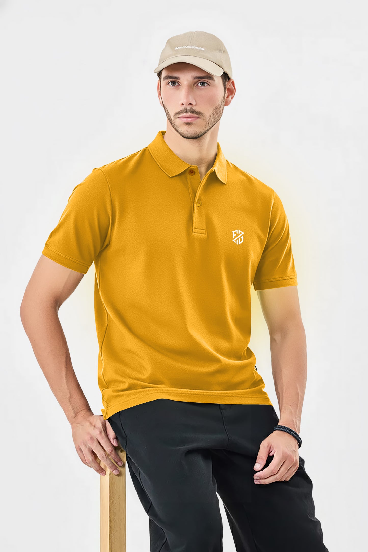 Man in mustard yellow polo shirt with embroidered logo, black pants, and beige cap