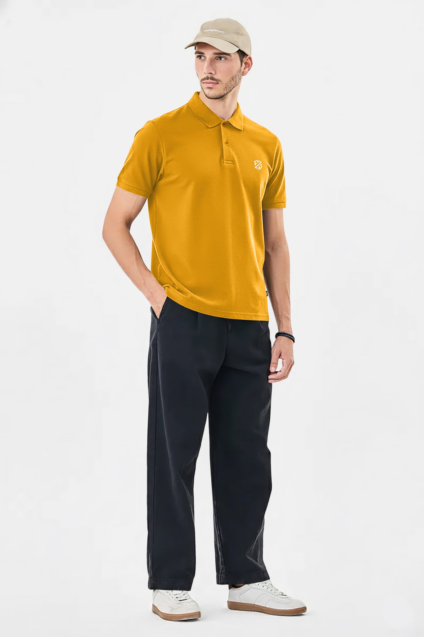 Man wearing mustard yellow polo shirt, black trousers, beige cap and white sneakers
