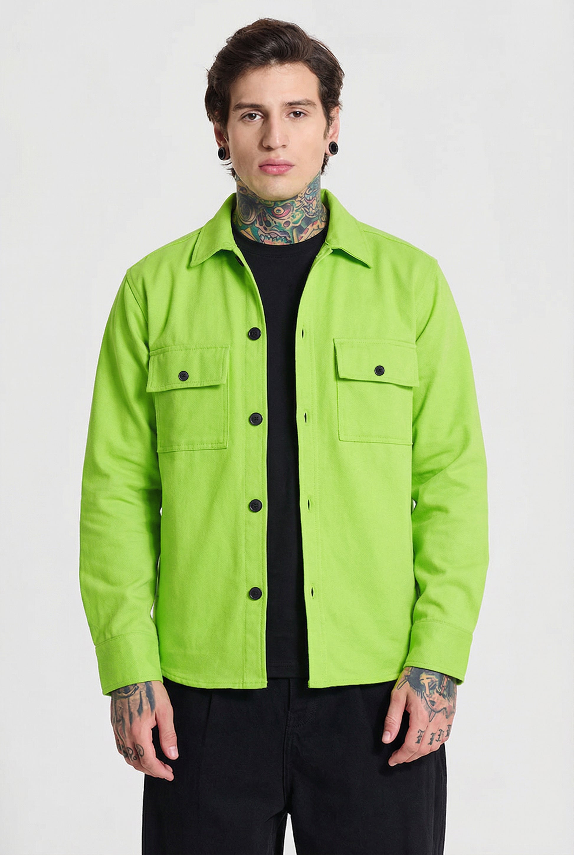 Man wearing a neon green button-up shirt with front pockets and black pants