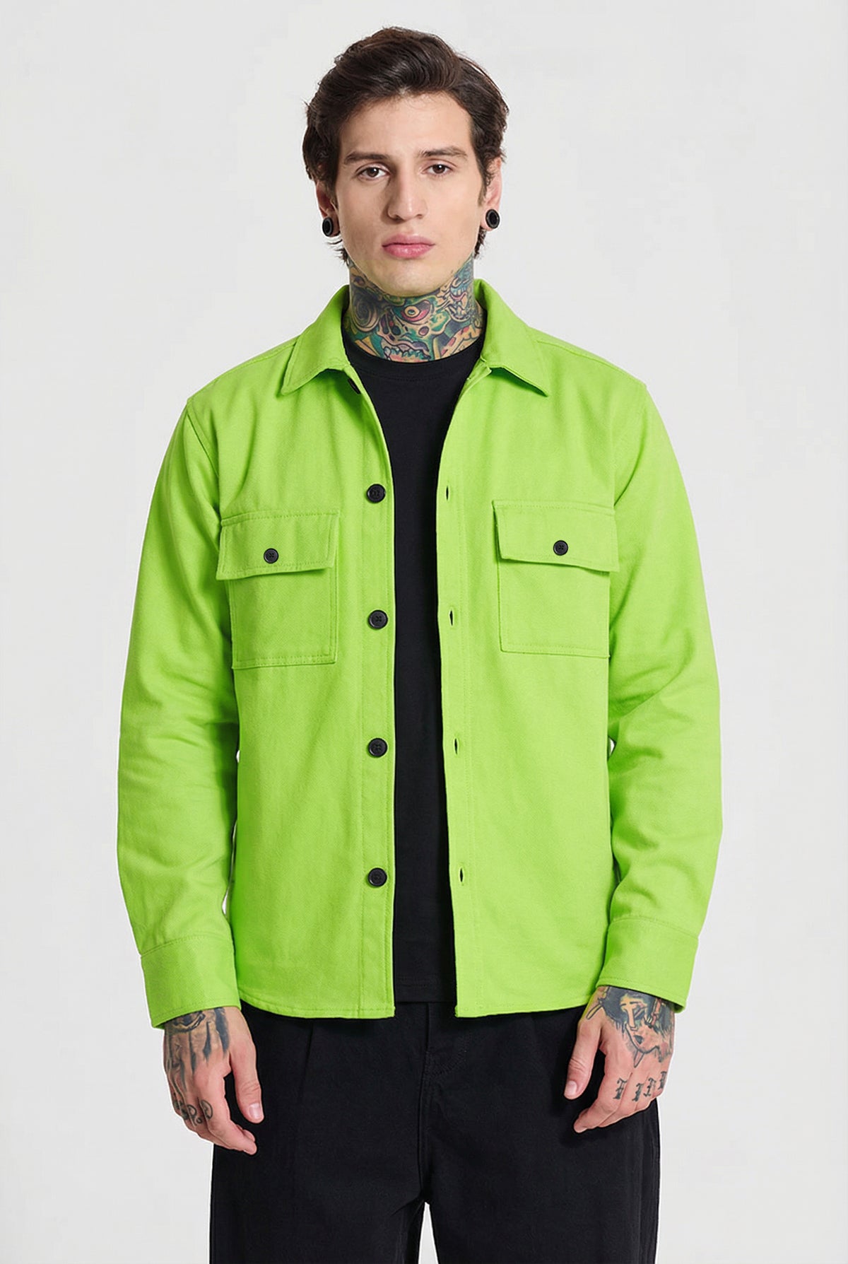 Man wearing a neon green button-up shirt with front pockets and black pants