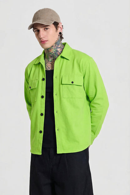 Man wearing lime green button-up shirt, beige cap, black tank top and black pants