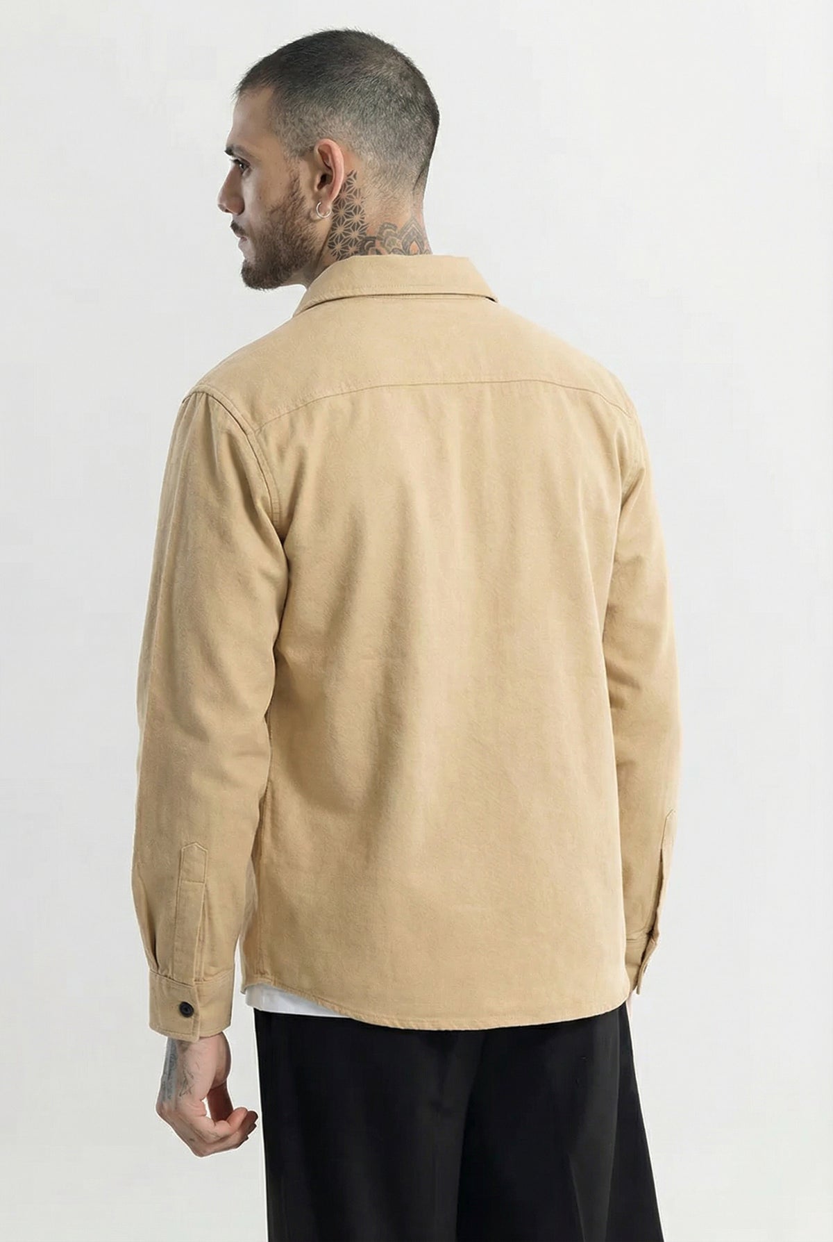 Man wearing beige button-up jacket, long sleeves, photographed from the back