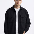 Man wearing a black button-up overshirt with chest pockets over a white t-shirt