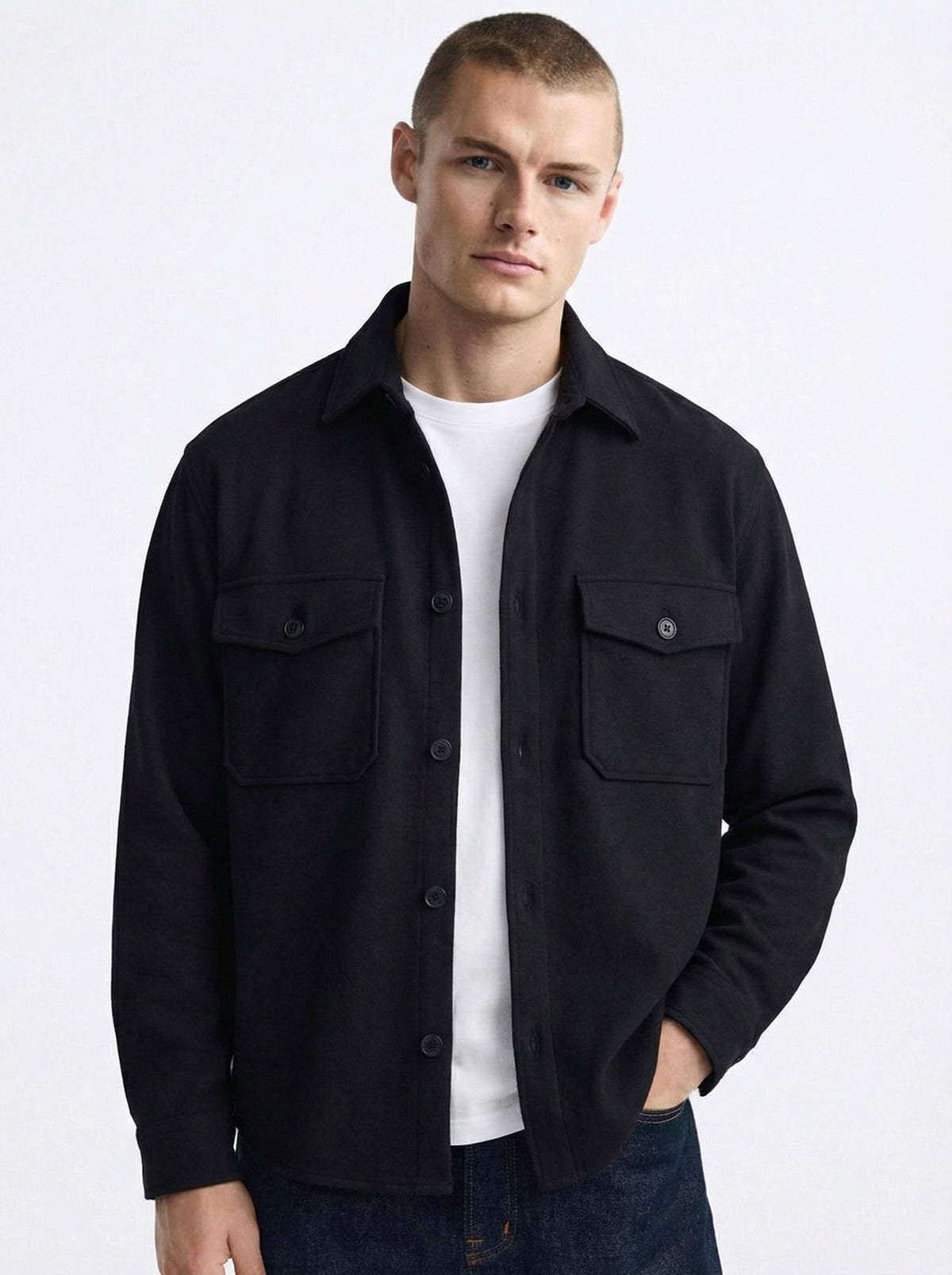 Man wearing a black button-up overshirt with chest pockets over a white t-shirt