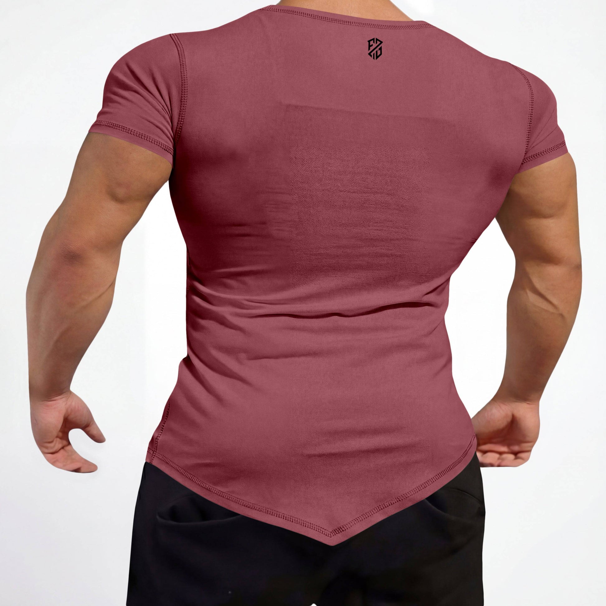 Man wearing fitted maroon short sleeve shirt with pointed hem and black athletic pants