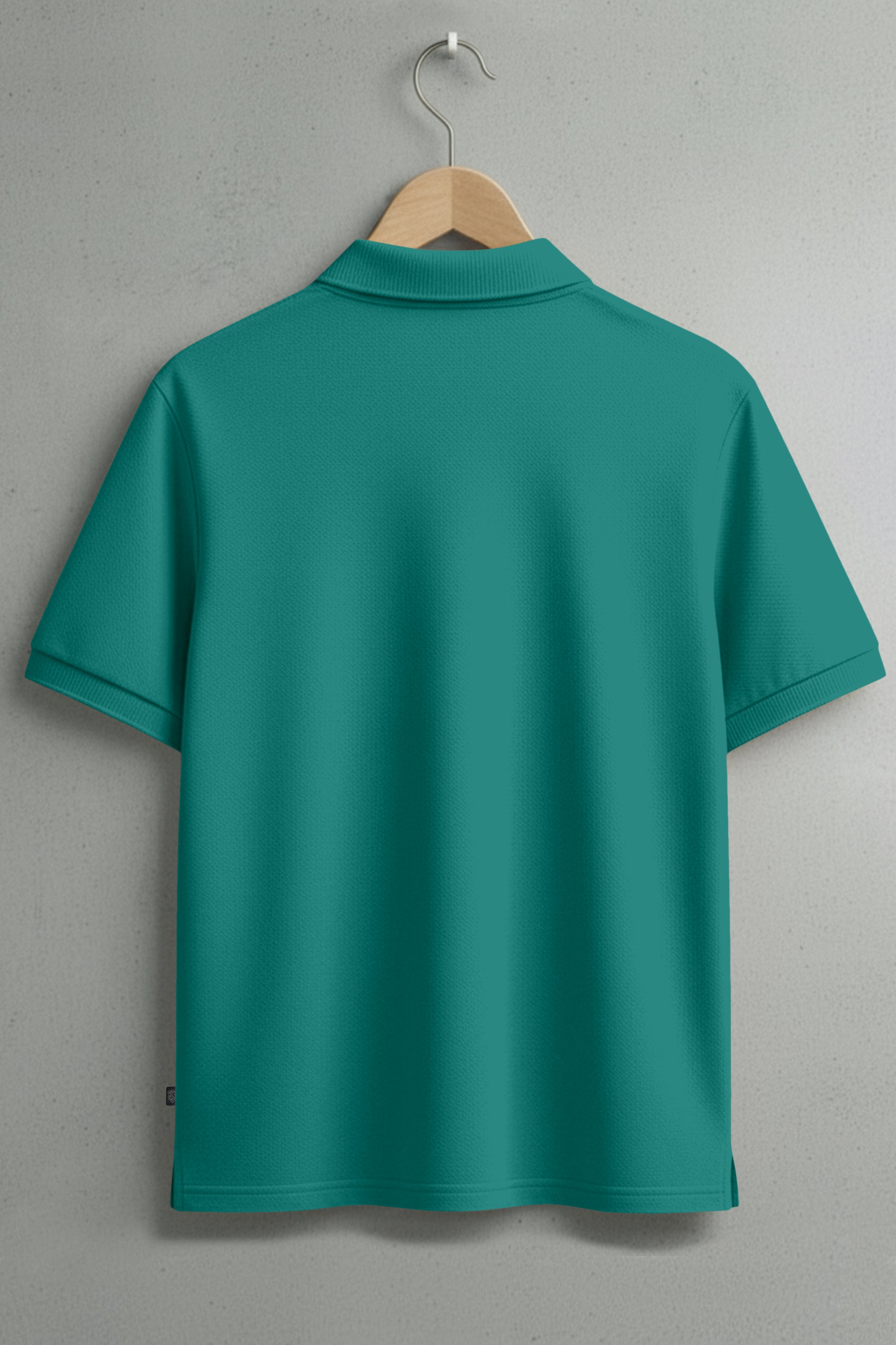 Back view of plain teal short-sleeve polo shirt on hanger against gray wall