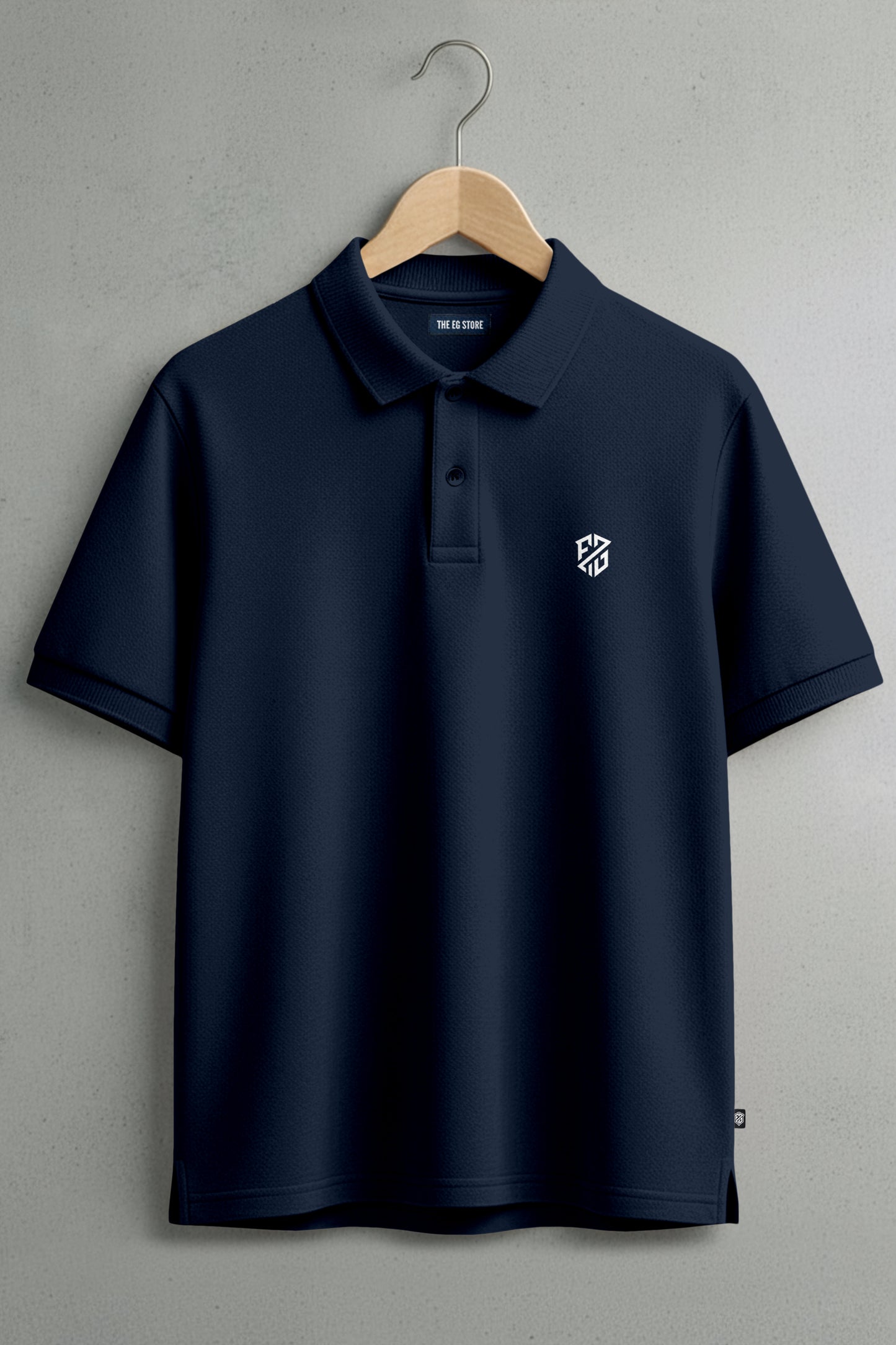 Navy blue polo shirt with white embroidered logo on chest, displayed on wooden hanger