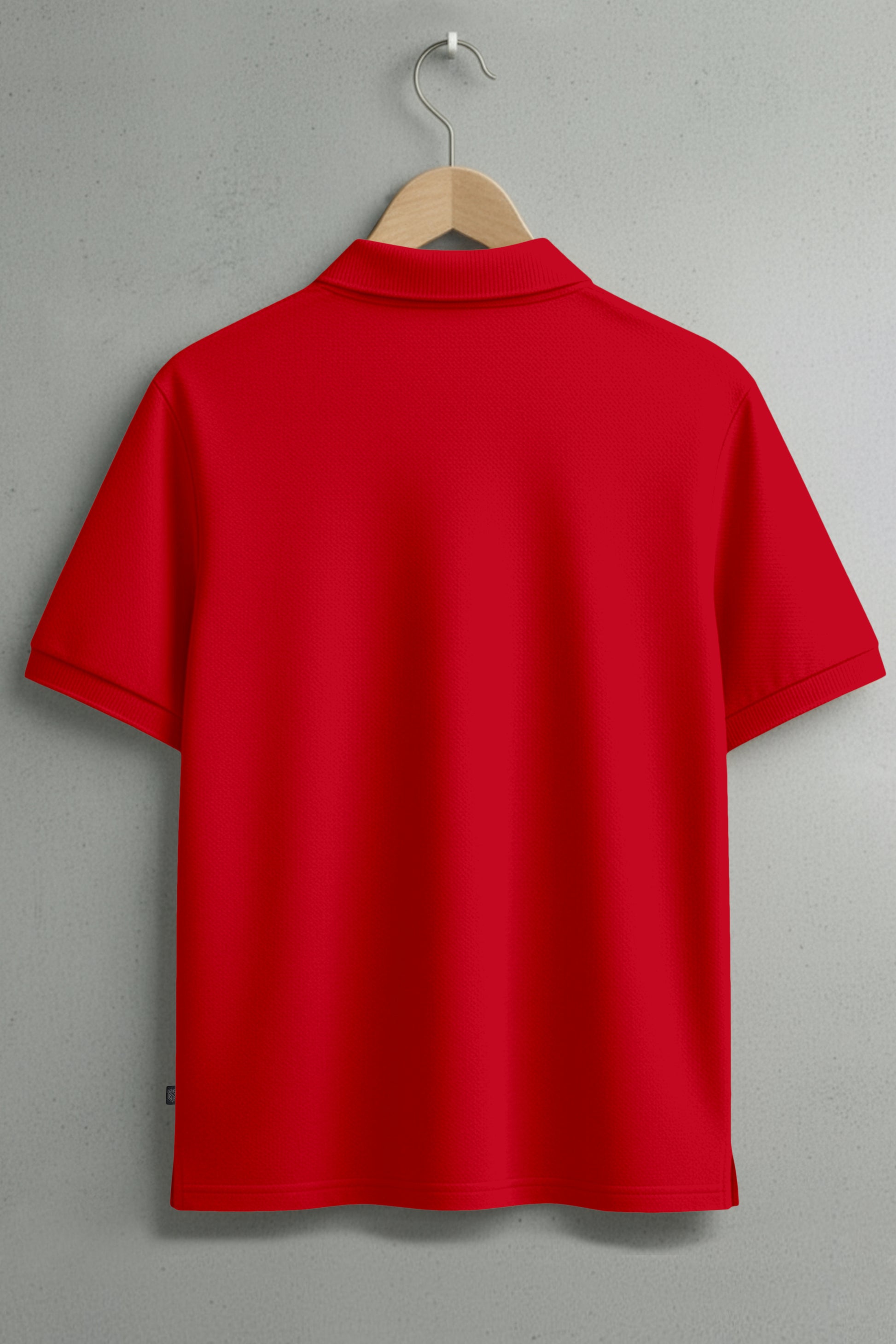 Back view of plain red short sleeve polo shirt on hanger against gray wall
