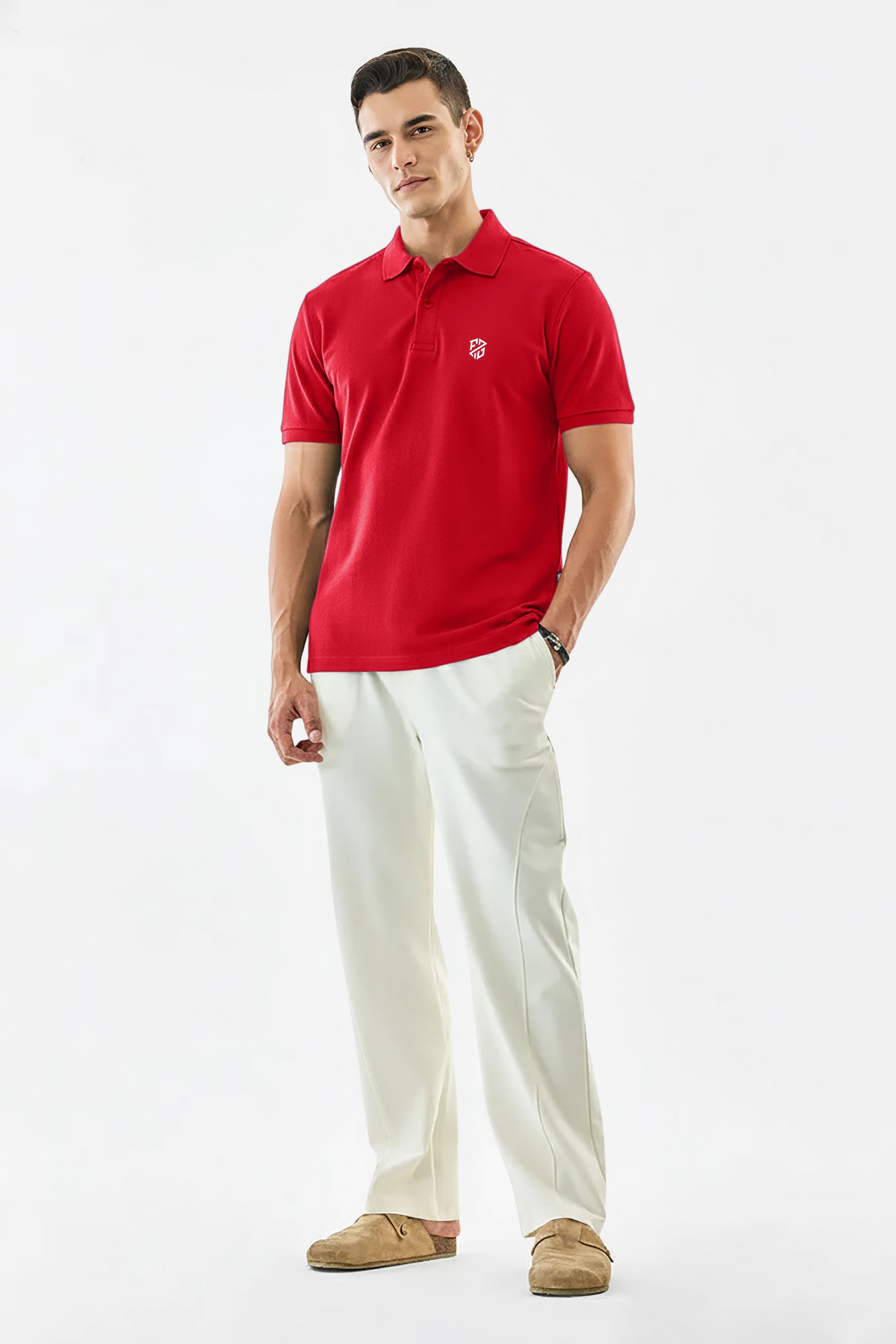 Man wearing a red polo shirt with logo, white trousers, and tan loafers on white background