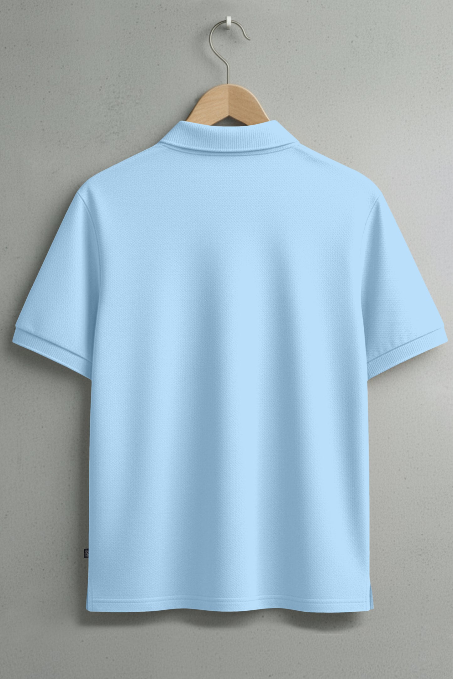 Light blue short sleeve polo shirt on wooden hanger, back view, plain wall background