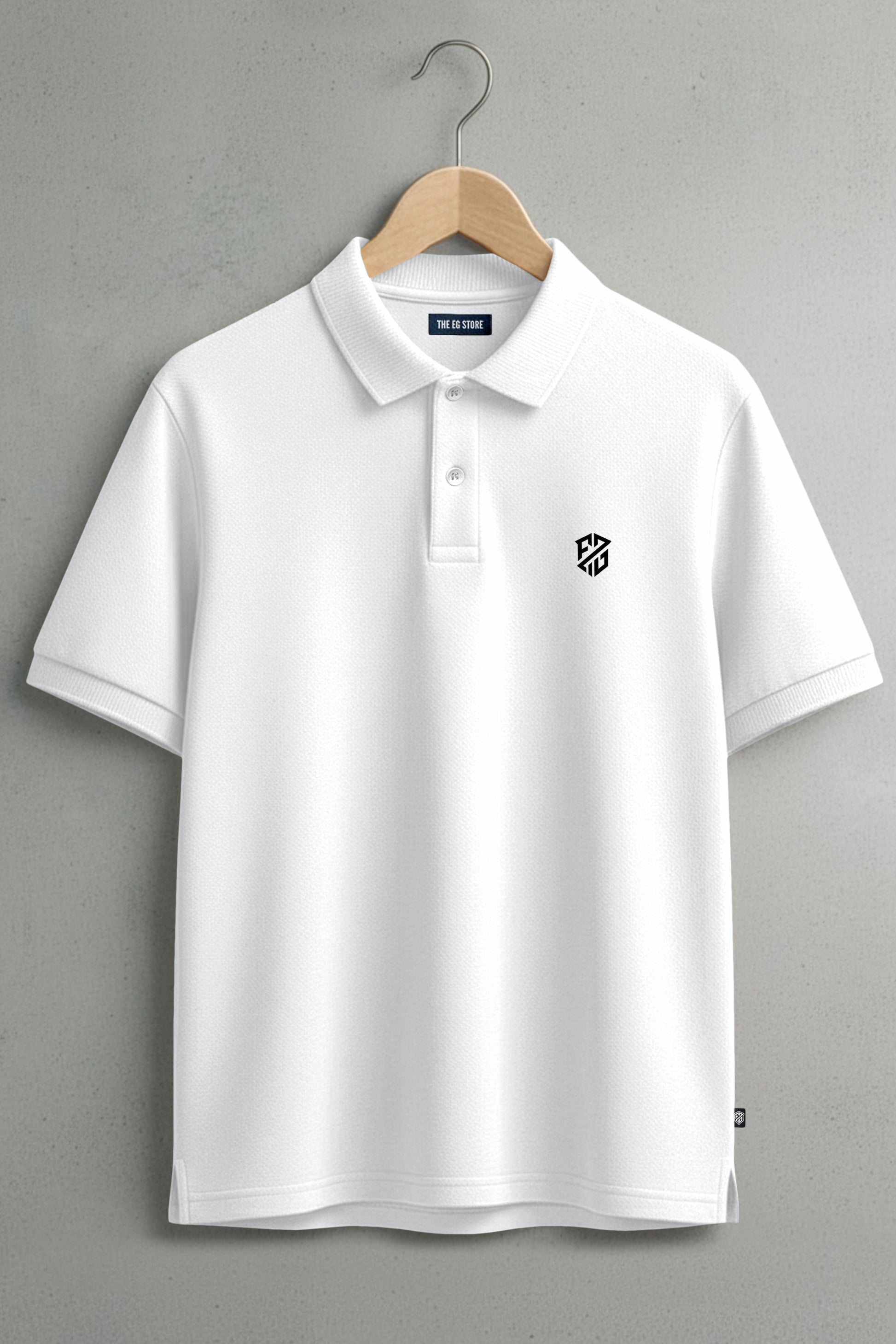 White polo shirt with short sleeves and geometric chest logo, hanging on wooden hanger