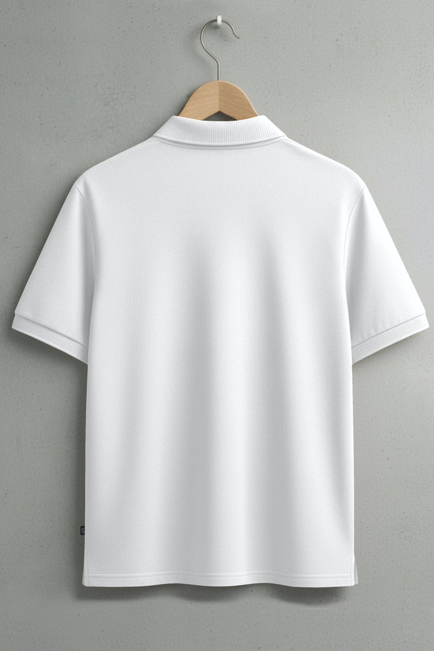 Back view of plain white short sleeve polo shirt on hanger against grey wall