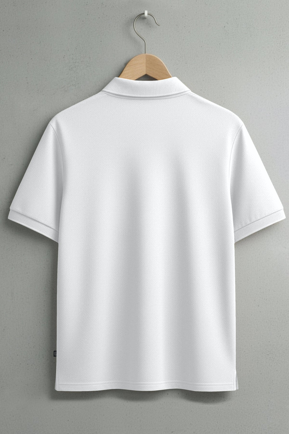 Back view of plain white short sleeve polo shirt on hanger against grey wall