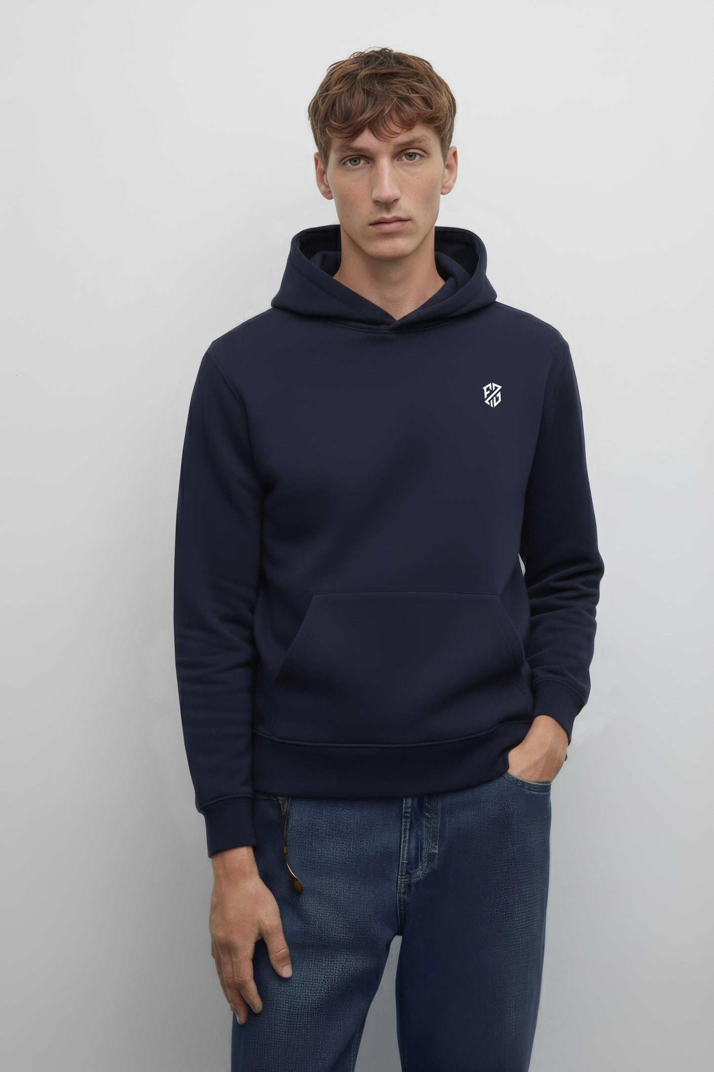 Male model in navy blue hoodie with white chest logo and front pocket, casual jeans style