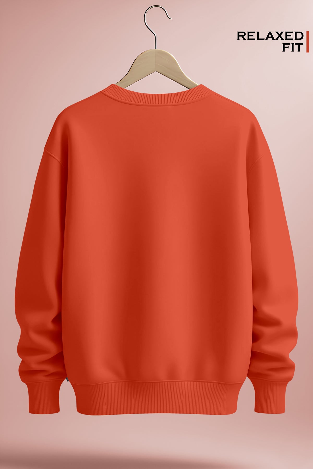 Back view of an orange relaxed fit crewneck sweatshirt on a hanger against a pink background.