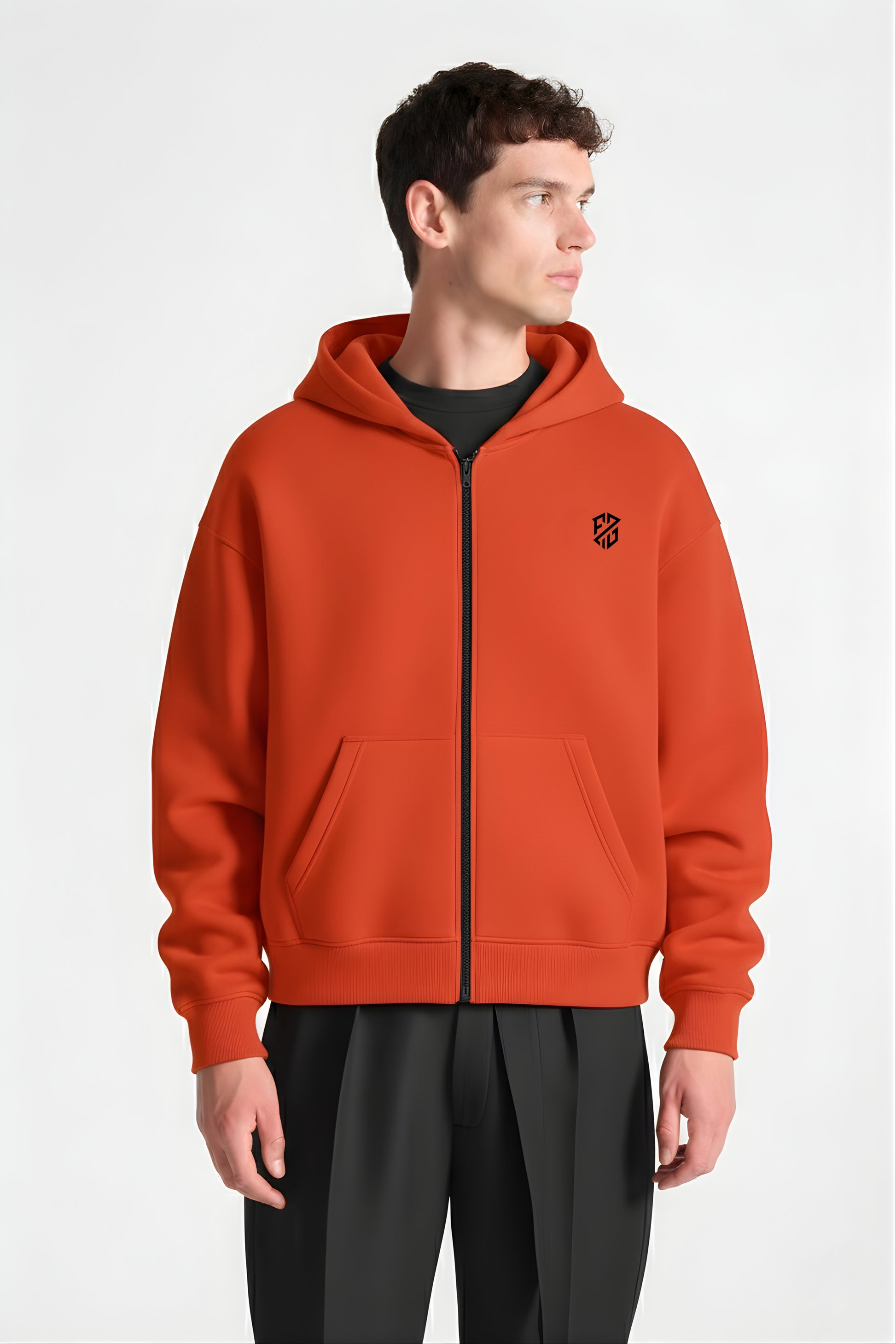 Man wearing orange zip-up hoodie with front pockets and black geometric logo, white background