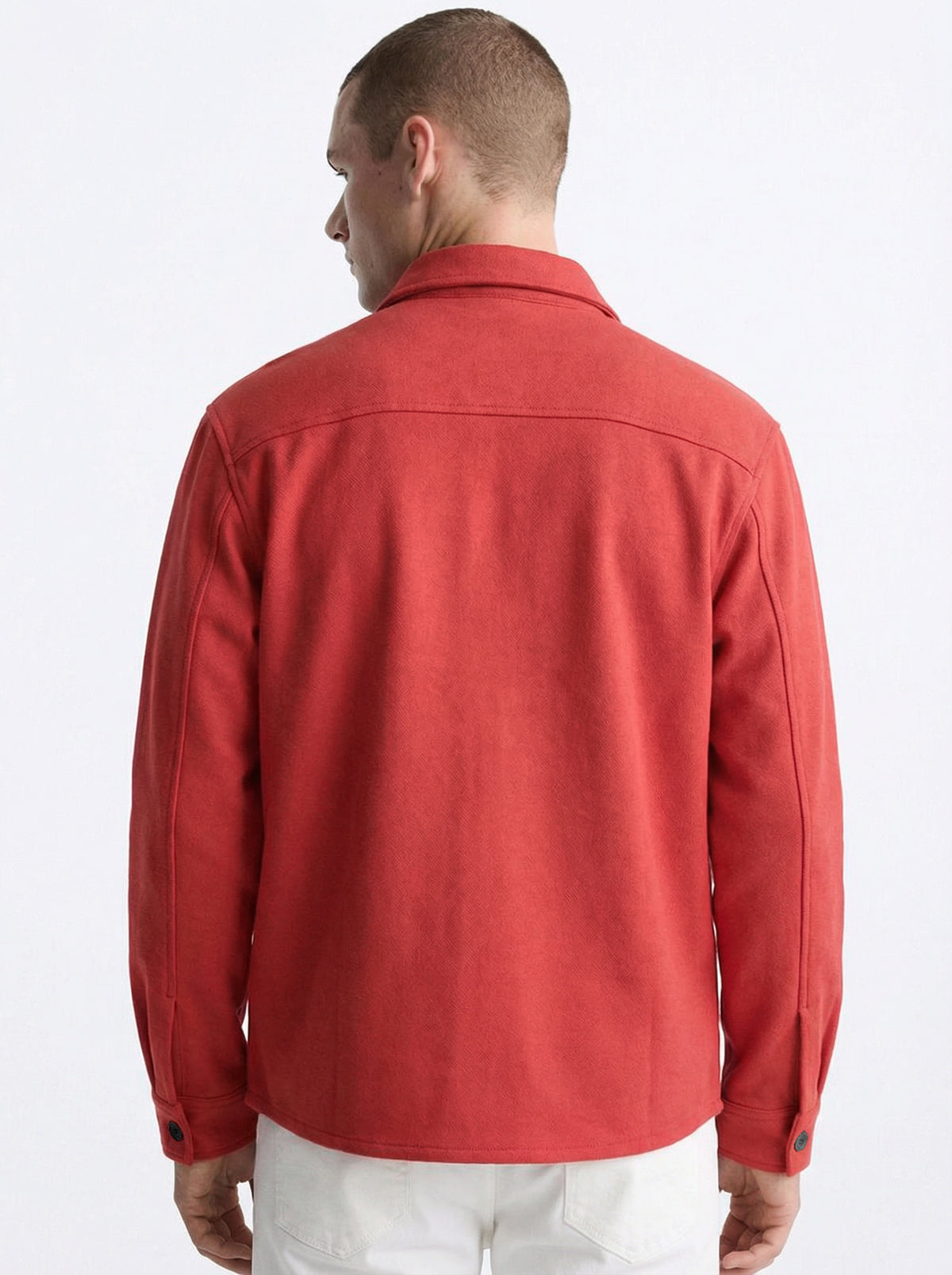 Back view of man wearing red long-sleeve shirt with collar and button cuffs