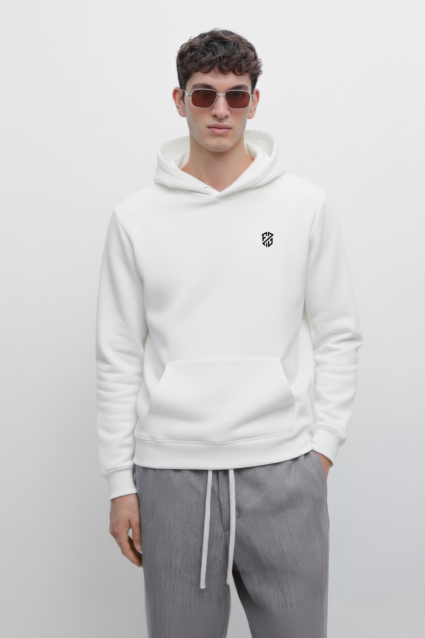 Man in white hoodie with black logo, wearing sunglasses and gray drawstring pants