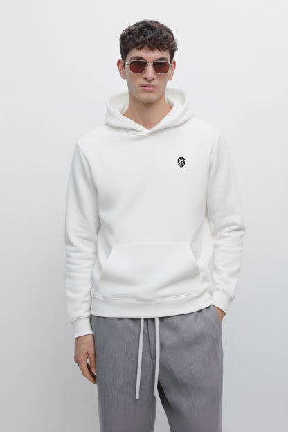 Man in white hoodie with black logo, wearing sunglasses and gray drawstring pants