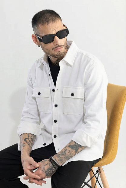Man wearing a white button-up shirt with black buttons, sunglasses, and visible tattoos