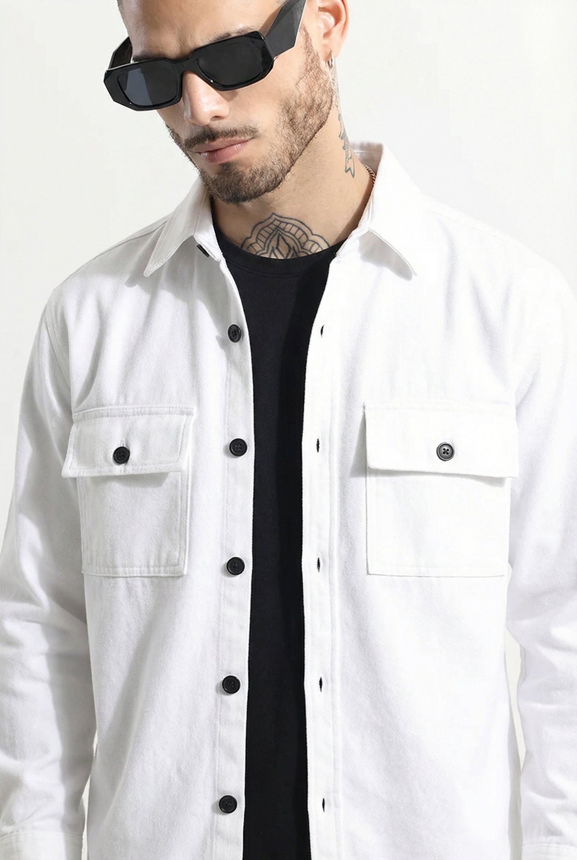 Man wearing white button-up shirt with chest pockets, black t-shirt, and sunglasses