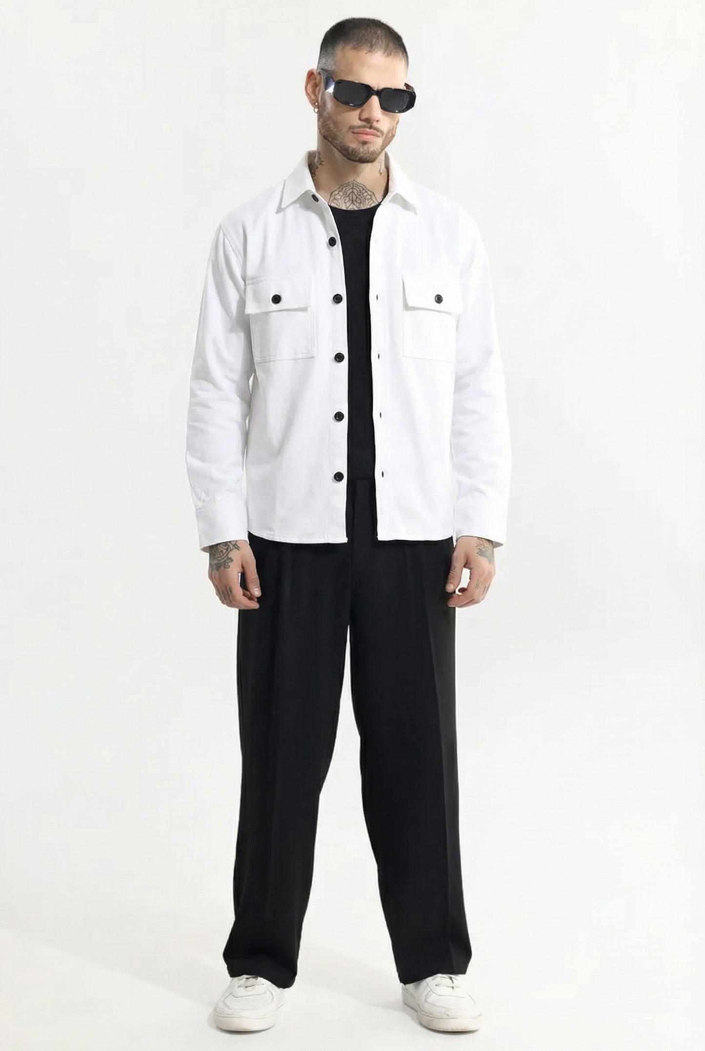 Man wearing white button-up shirt, black wide-leg pants, black sunglasses, and white sneakers