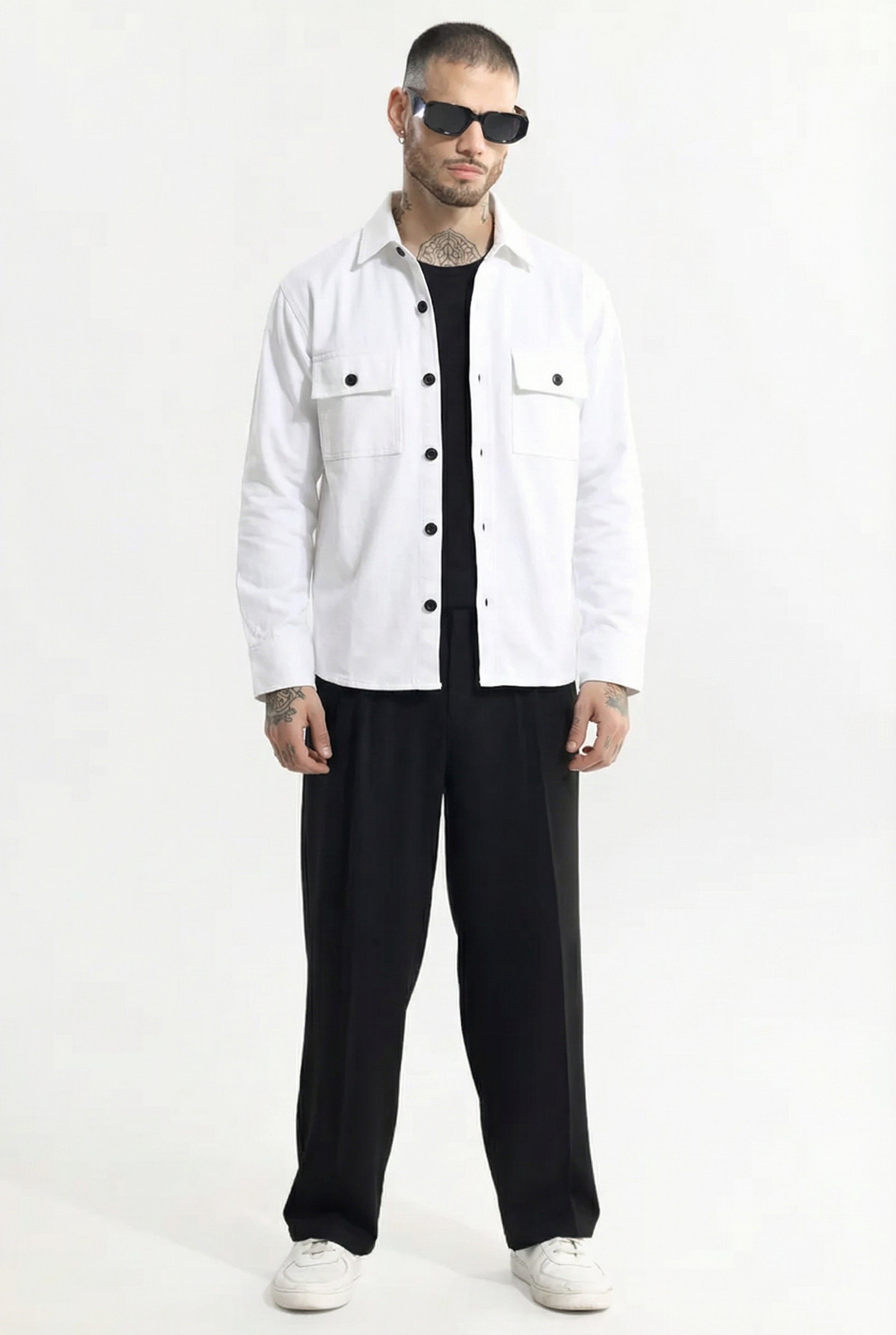 Man wearing white button-up shirt, black wide-leg pants, black sunglasses, and white sneakers