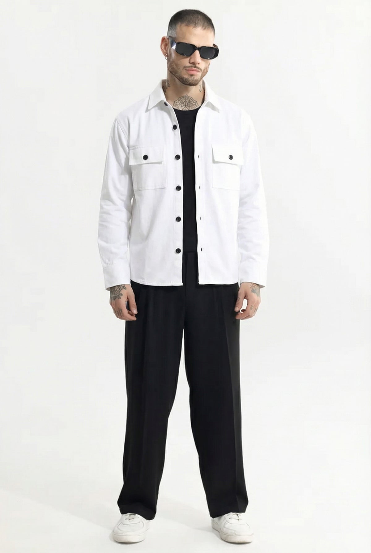 Man wearing white button-up shirt, black wide-leg pants, black sunglasses, and white sneakers