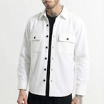 Man wearing a white button-up shirt jacket with front pockets and black pants