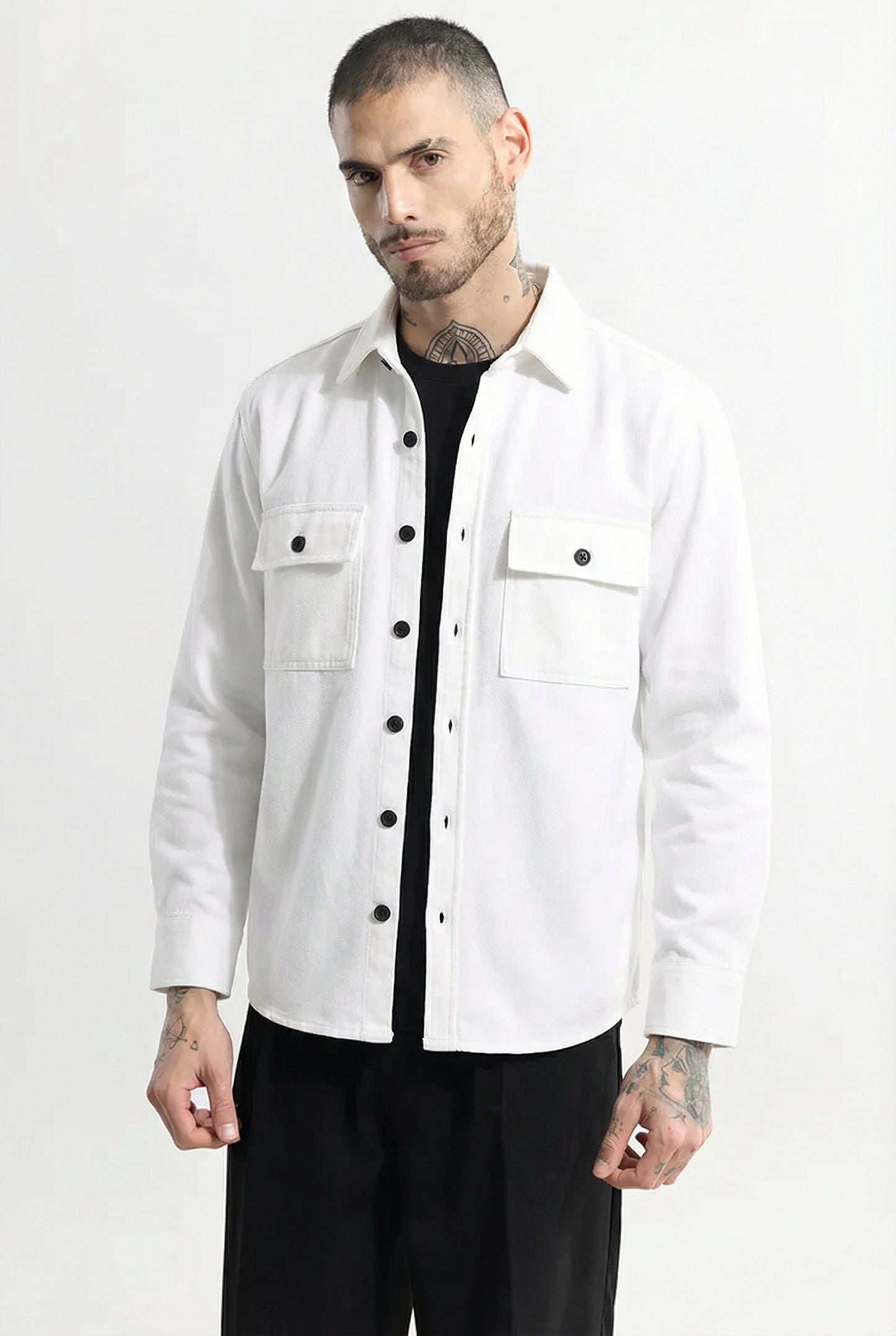 Man wearing a white button-up shirt jacket with front pockets and black pants