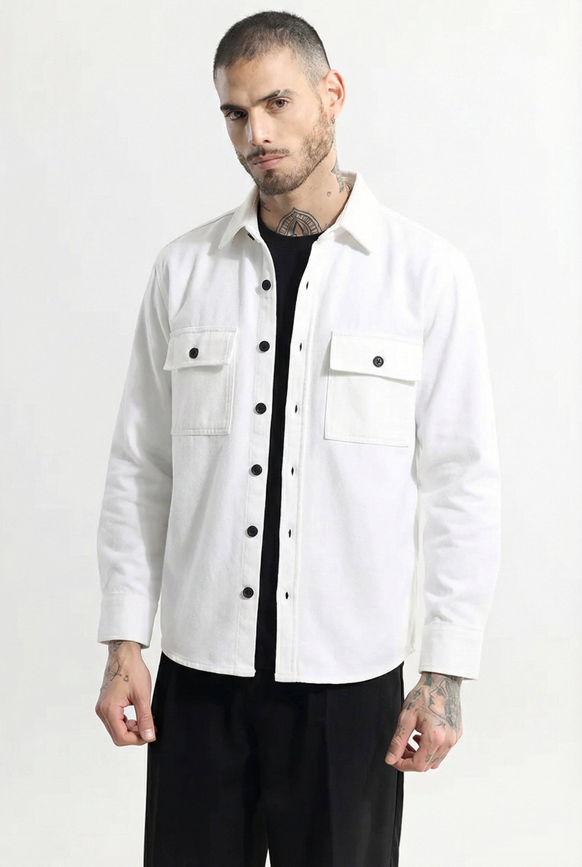 Man wearing a white button-up shirt jacket with front pockets and black pants