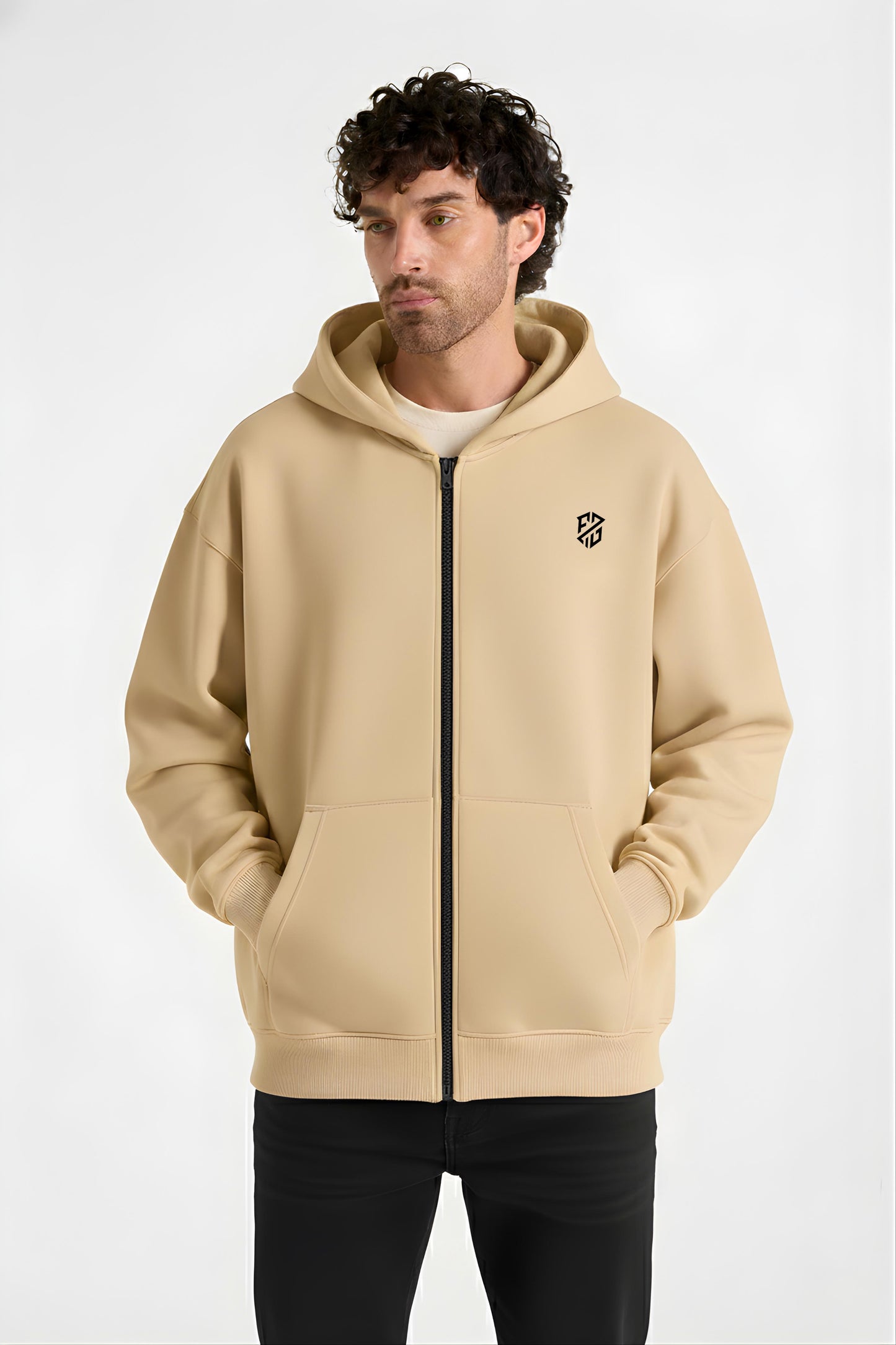 Man wearing a beige zip-up hoodie with black logo and front pockets, casual fashion
