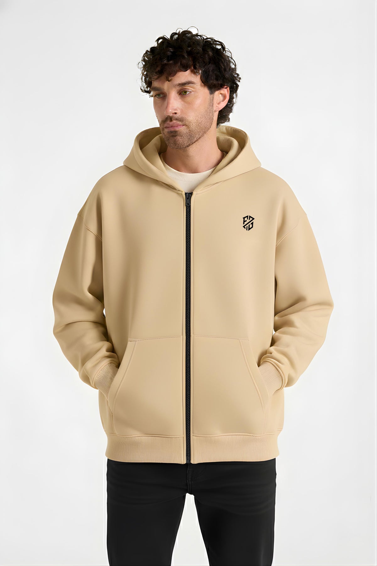 Man wearing a beige zip-up hoodie with black logo and front pockets, casual fashion