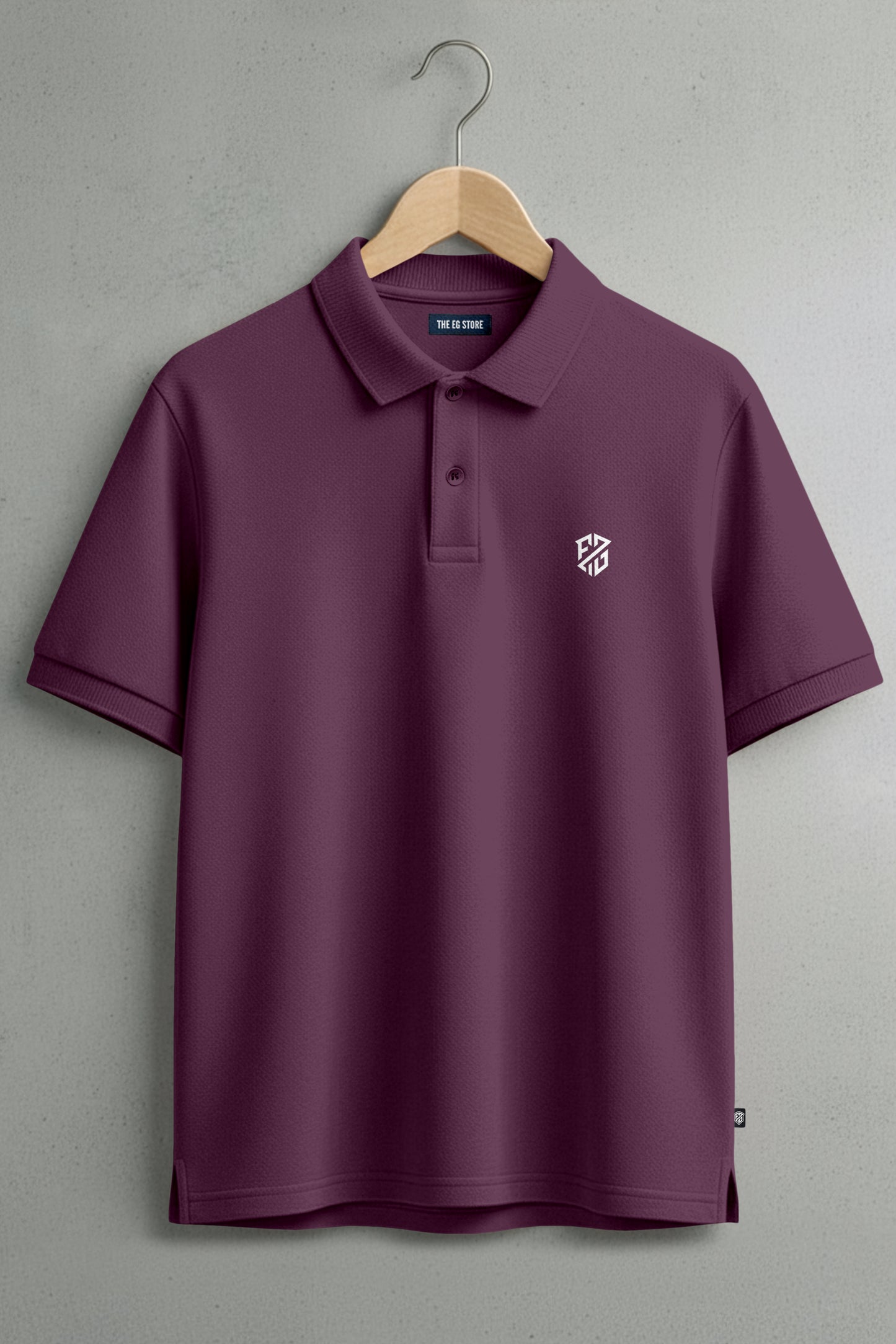 Maroon short sleeve polo shirt with collar, button placket, and white chest logo on hanger